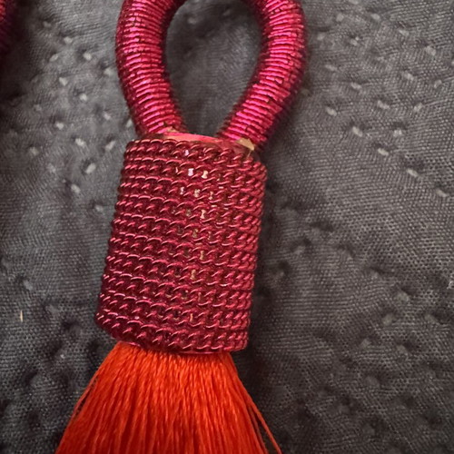Red earrings with intricate binding and tassel like new
