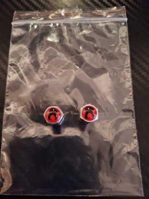 Silver valve caps with red and black detail and African symbol like new