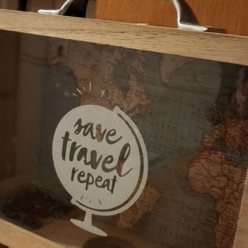 Decorative travel suitcase piggy bank used with map