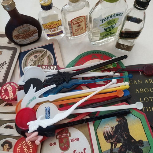 Vintage bar collection with mini liquor bottles, coasters, and stirrers