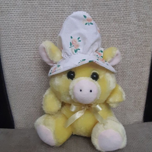 Yellow plush piglet with fabric hat and bow