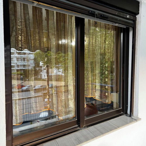 Aluminum sliding windows with dark brown shutters and screens used, set of multiple pieces