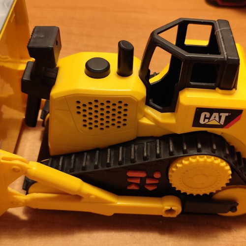 CAT bulldozer toy used with moving tracks and gradual forward-back motion