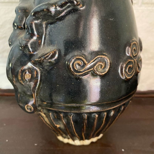 Black ceramic vase with ram’s head decoration