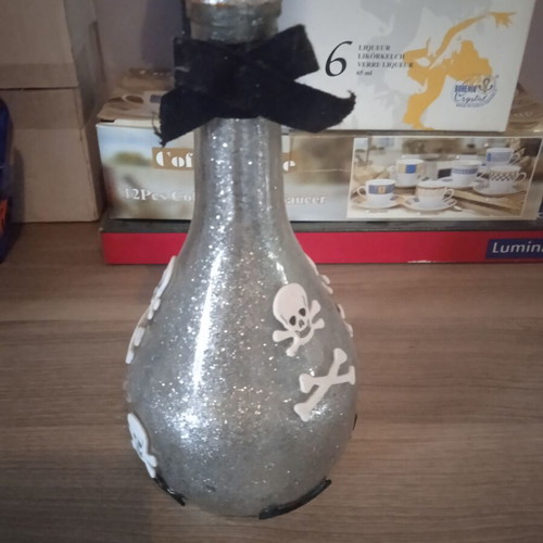 Decorative bottle with skulls like new, silver color