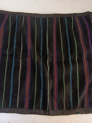 Traditional apron with colorful vertical stripes, used