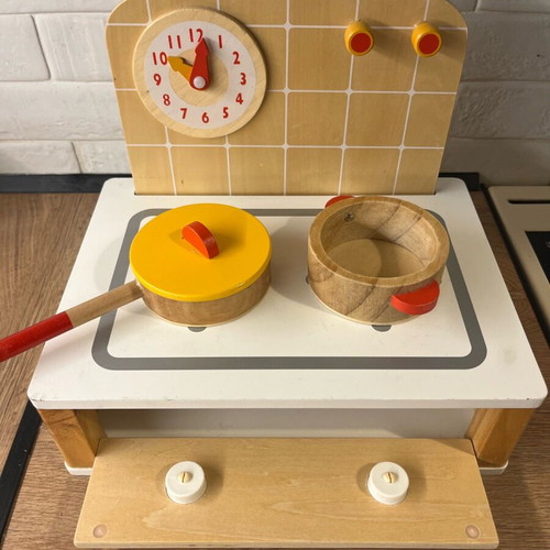 Wooden play kitchen with wooden cooking utensils used