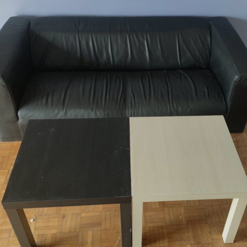 Black leather three-seater sofa used with coffee tables