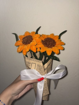 Handmade sunflower bouquet wrapped in decorative paper with satin ribbon