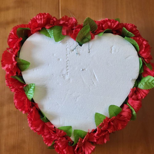 Heart made of artificial red flowers like new