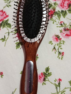Small hairbrush with metal pins and rubber cushion