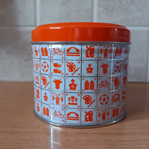 Metal biscuit tin like new with orange lid and designs