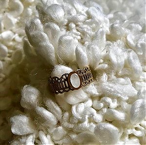 Ατσάλινο δαχτυλίδι σεβαλιέ σε χρυσαφί χρώμα και οβάλ λευκή πέτρα.