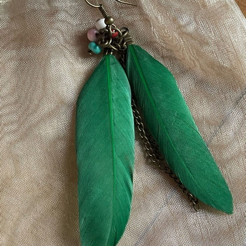 Handmade earrings used with green feathers and multicolored beads