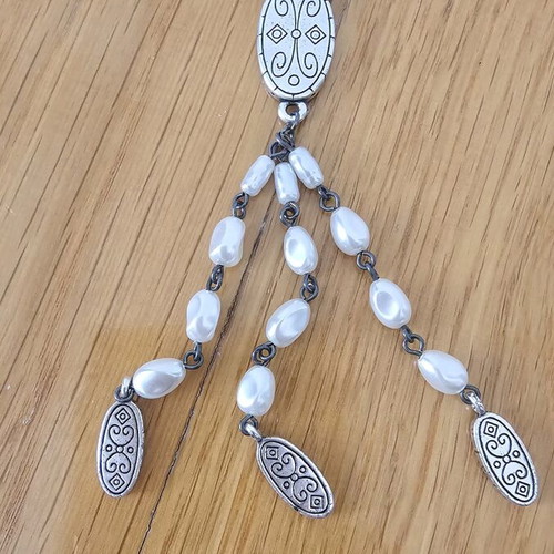 Necklace used with drop-shaped pearls and silver metal details