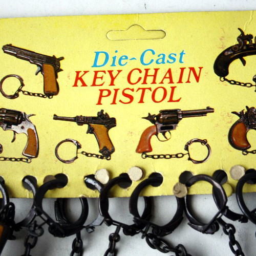 Card with 12 vintage 80's Colt 45 metal pistol keychains new