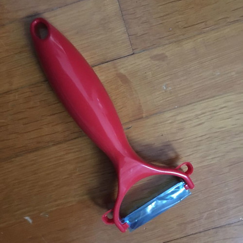 Red peeler new with thick handle made of durable plastic