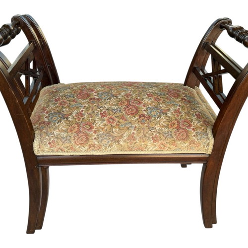 Wooden stool with carved high arms
