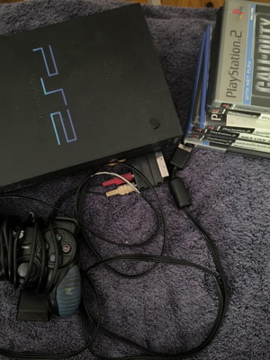 PlayStation 2 (PS2) console like new with 8 games and 2 controllers