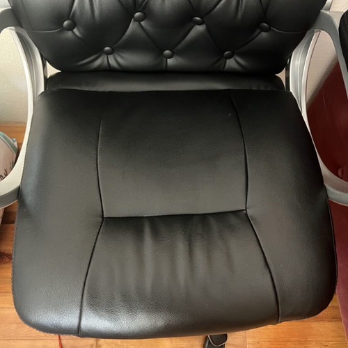 Office chair with black faux leather upholstery and button-tufted back