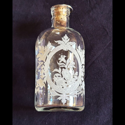 Glass apothecary bottle used with etched floral design