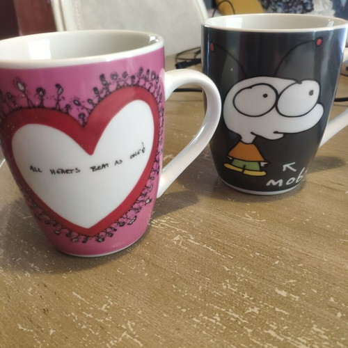 Two collectible mugs like new, featuring Moby and Charlize Theron design