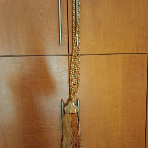 Curtain tieback used, gold-orange color