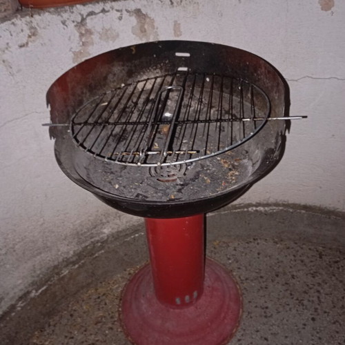 Portable vintage charcoal barbecue with red central leg, used