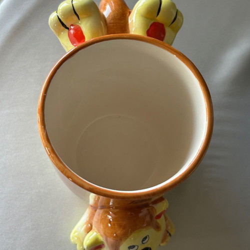 Vintage ceramic mug with embossed monkey design, used