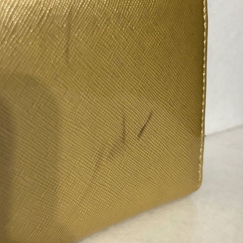 Two gold wallets, one with wrist strap