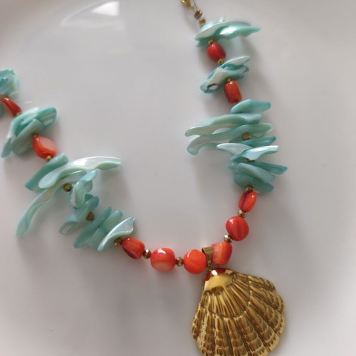 Necklace with shell chips and steel clam pendant