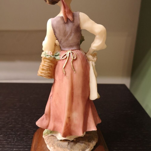 Porcelain figure used with wooden base and girl carrying flowers