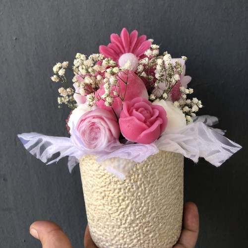 Flower arrangement with scented candles in plaster vase