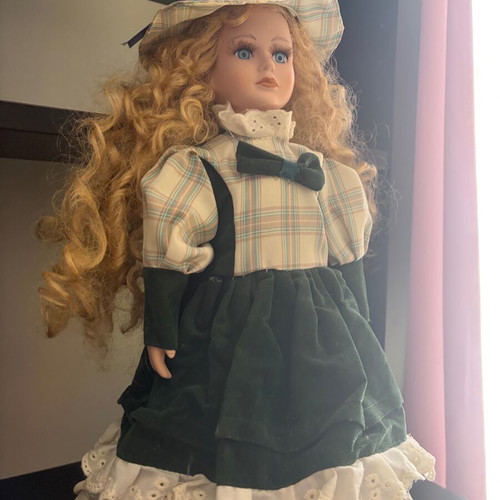 Porcelain doll like new with curly blonde hair and hat