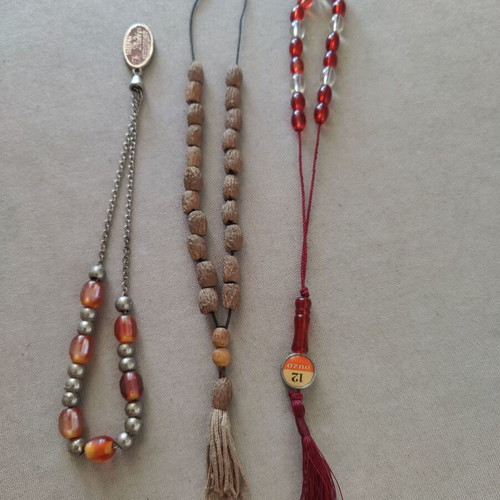 Set of three old komboloi, including handcrafted olive stone and red Ouzi