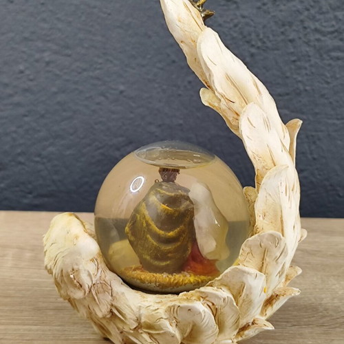 Christmas decorative snow globe featuring the Nativity and a base shaped like an angel's wing