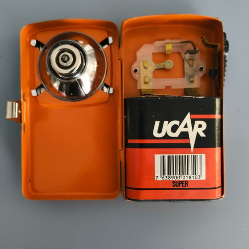 Vintage orange flat pocket flashlight used with retro UCAR battery