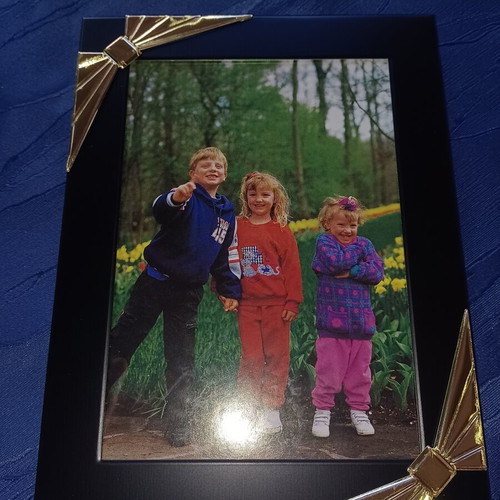Black photo frame with golden decorative bows used