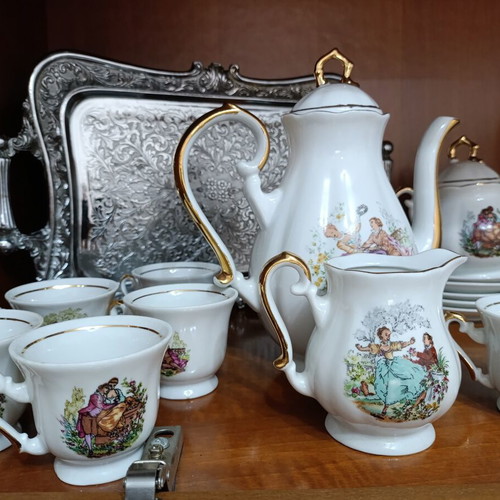 Vintage porcelain coffee and tea set with gold details and romantic scenes