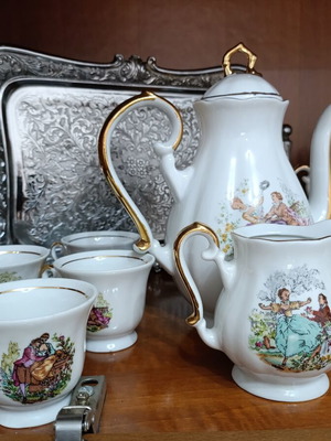 Vintage porcelain coffee and tea set with gold details and romantic scenes