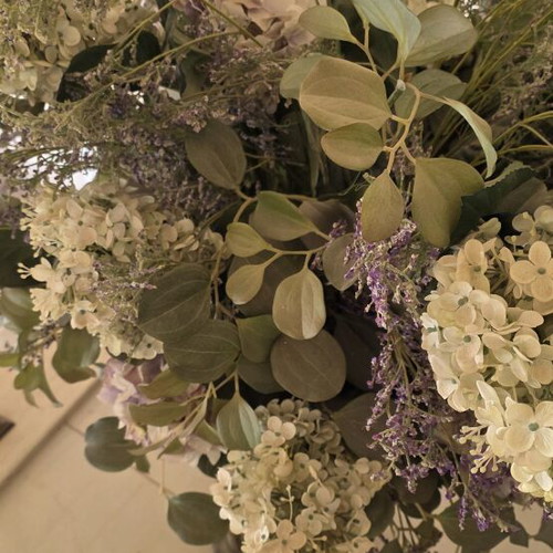 Artificial flower arrangement with hydrangeas and eucalyptus in clay floor vase