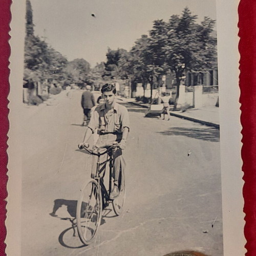 Vintage black and white photo of young man with bicycle on street, like new