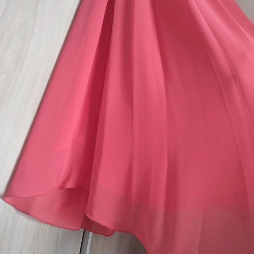 Coral dress with a jewel tie at the neck