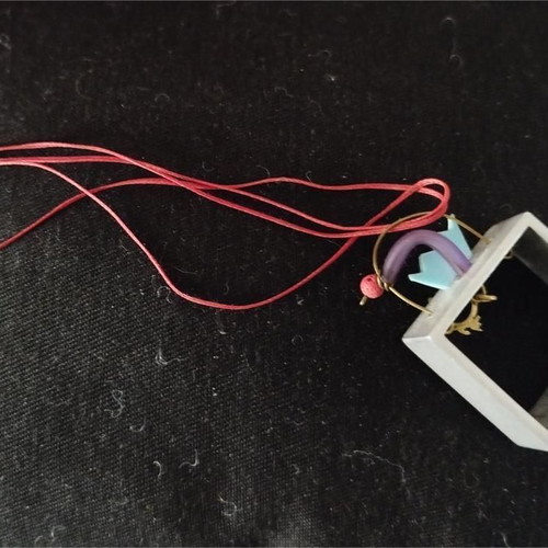 Sculpted pendant like new with square frame and red cord