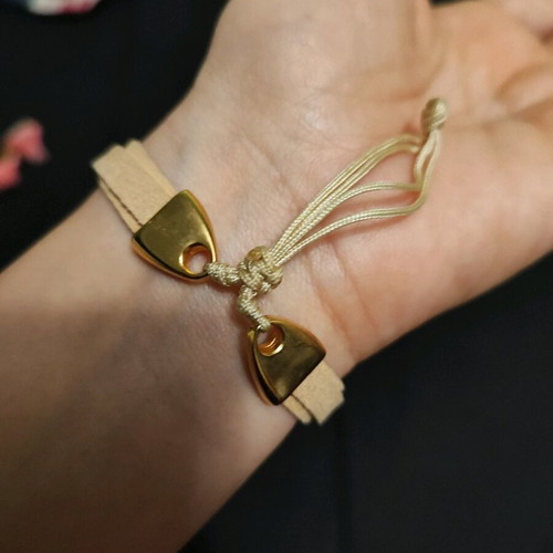 Bracelet with metal triangle and eye charm in light beige like new
