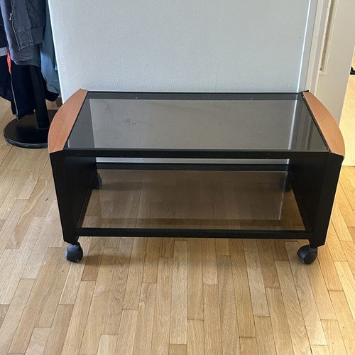 Coffee table with glass top, black metal frame and wooden corners
