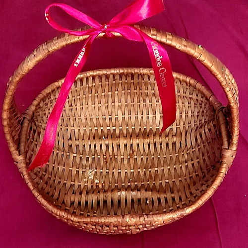 Woven straw basket used with red satin ribbon