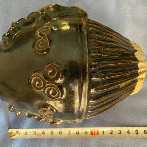 Black ceramic vase with ram’s head decoration