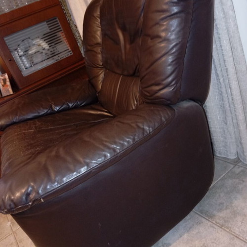 Leather recliner armchair used with wear on seat and footrest