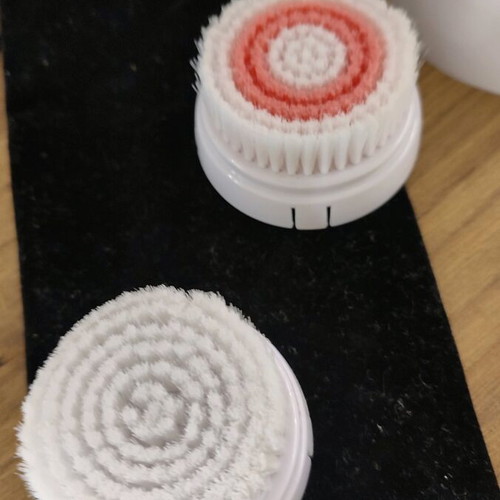 Facial cleansing device used with two heads and stand